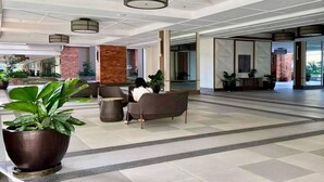 A spacious lobby with a seating area, a large potted plant, and a modern ceiling design. - Cozy LUZZO HOME 1-br luxury condo in  Kapitolyo pasig area 2mins away from BGC (Pasig)
