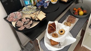 A breakfast setup with various food items and drinks on a table. - B&B Topaze (Sirmione)