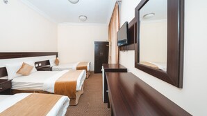 A hotel room with two beds, a wooden dresser, a flat-screen TV, and a door. - Jawharat Al Diyar - 1 (Makkah)