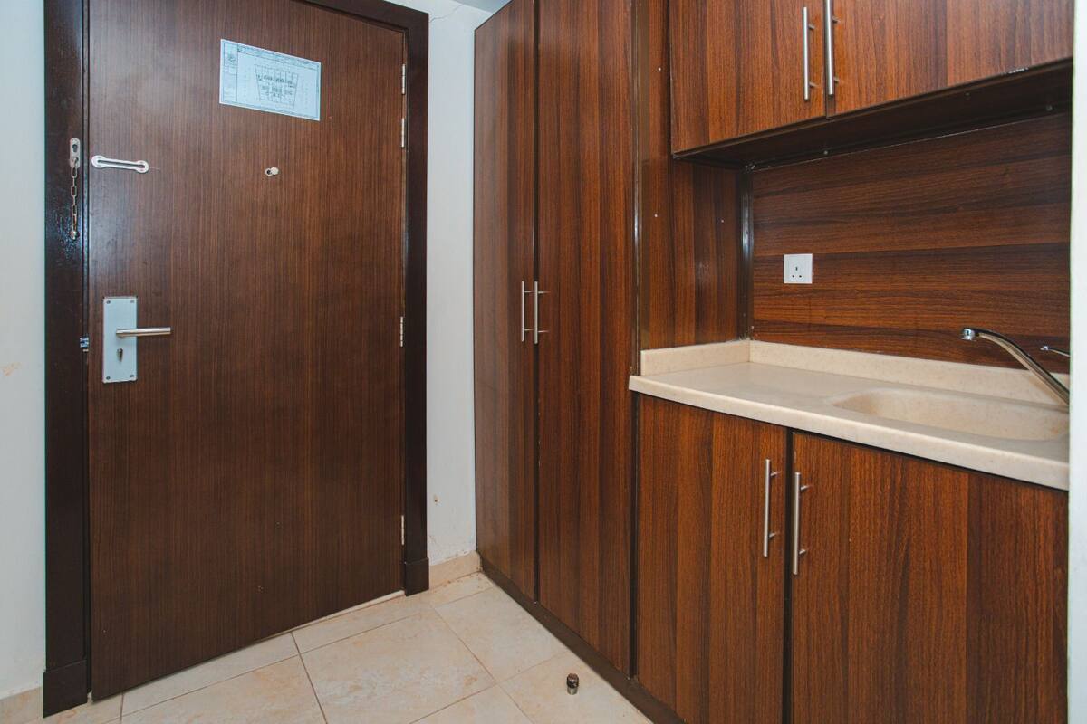 A wooden door with a metal handle and a small sign on it.