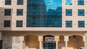A building with a large reflective glass facade, multiple windows, and a sign for the Jawahar Hotel. - Jawharat Al Diyar - 1 (Makkah)