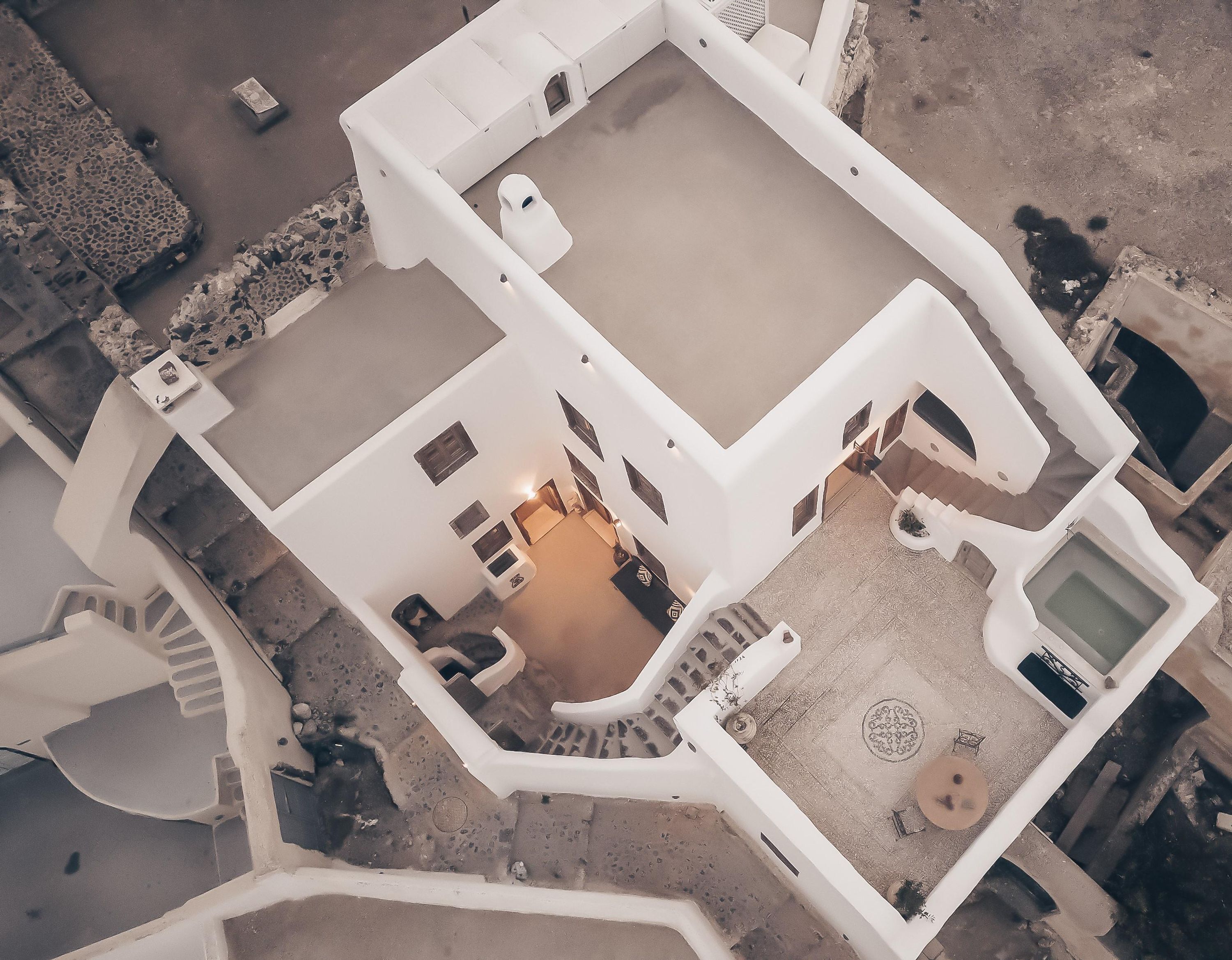 Vista aérea de un edificio moderno con un patio central, varias habitaciones y una zona de piscina.
