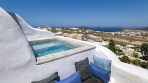A hot tub with a view of the sea and buildings. - Historical Villa Santa Croce (Santorini)