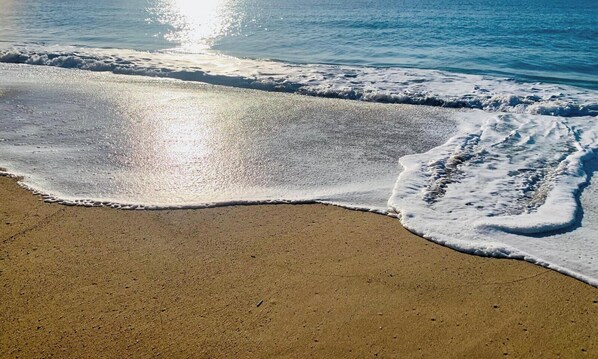 Una playa con olas que acarician suavemente la orilla.