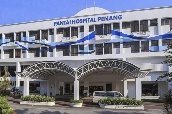 Pantai Hospital Penang with a white facade, blue accents, and a covered entrance. - The CEO SuiteZ2 By Homey Planet (Bayan Lepas)