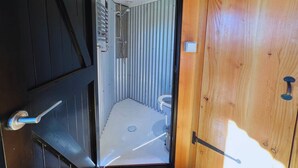 Ein kleines Badezimmer mit Dusche, Toilette und einem Waschbecken.