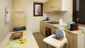 Une cuisine compacte avec des meubles en bois, un évier et un petit coin repas comprenant une chaise et une table.