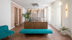 Una cucina moderna con isola centrale, pavimento in legno e parete in mattoni.