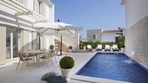 A modern outdoor pool area with a dining set and lounge chairs. - Vila Vita-Vabriga by Villas Guide (Tar)