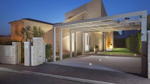 A modern house with a covered driveway, stone walls, and a well-lit entrance. - Vila Vita-Vabriga by Villas Guide (Tar)