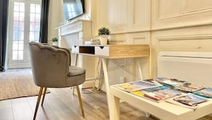 A room with a desk, chair, flat-screen TV, and a radiator. - Historic Centre Studio, 50 m from Quimper Cathedral, Charm & Comfort (Quimper)