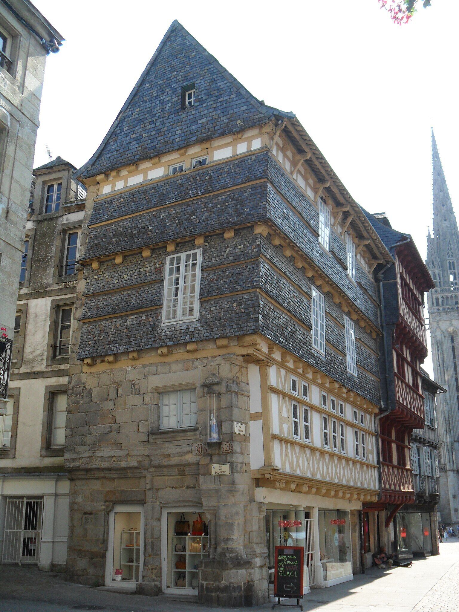 Um edifício histórico com telhado íngreme e uma combinação de pedra e estrutura de madeira.