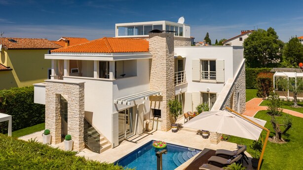 A modern two-story house with a swimming pool, outdoor seating, and a stone facade. - Villa Ginevra by Villas Guide (Tar)