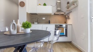 Eine moderne Küche mit weißen Schränken, einer schwarzen Arbeitsplatte und einem Edelstahlbackofen.