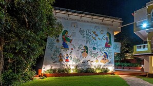 A building with a mural depicting traditional figures and nature scenes. - Hotel Hilltop by Fidato Hotels (Panhala)