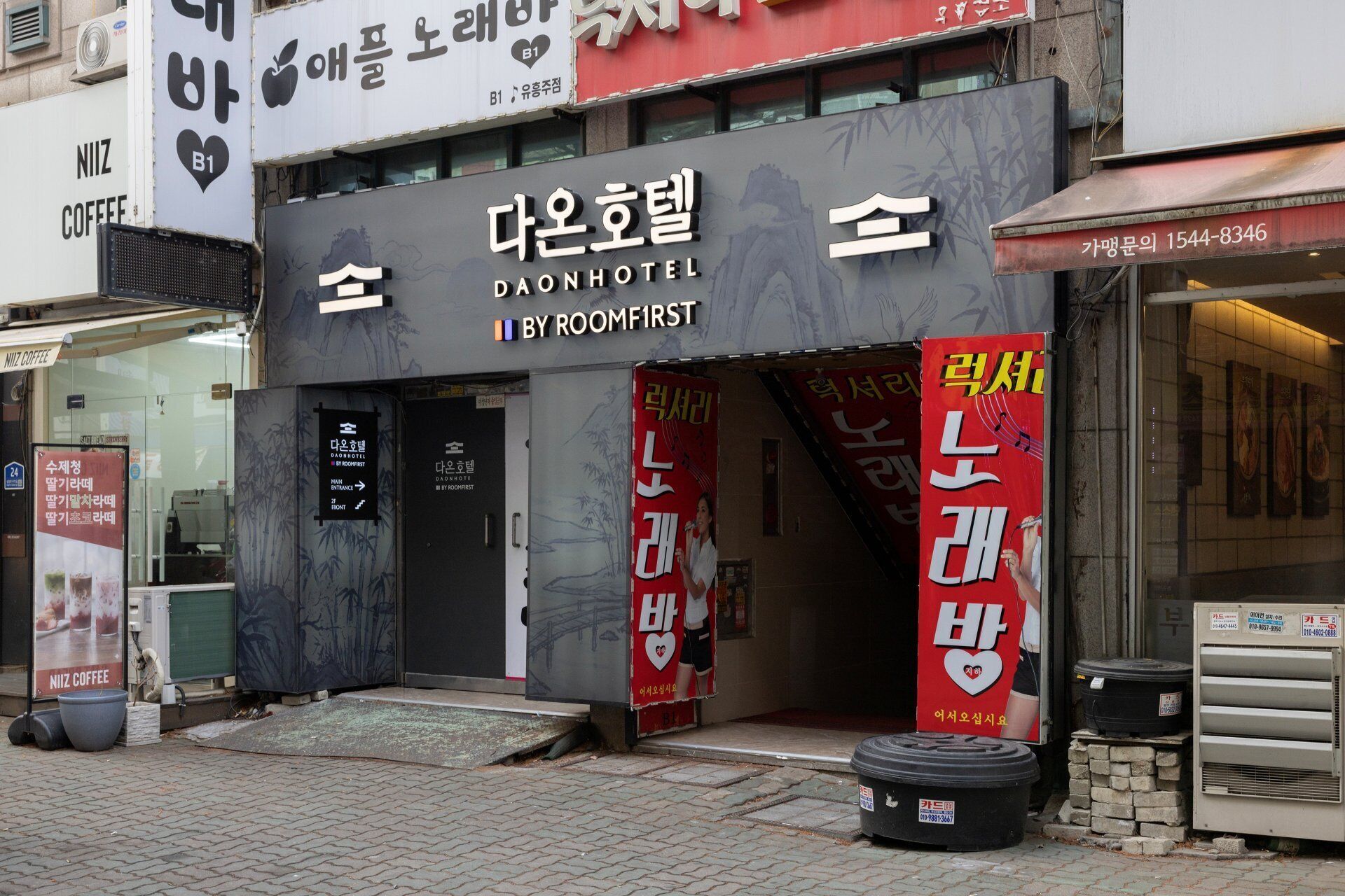 A hotel entrance with a sign for Daon Hotel by RoomFirst.