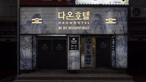 Het uiterlijk van Hotel Daon, met traditionele Koreaanse architectuurelementen en een bord dat aangeeft dat het wordt beheerd door Roomfirst.