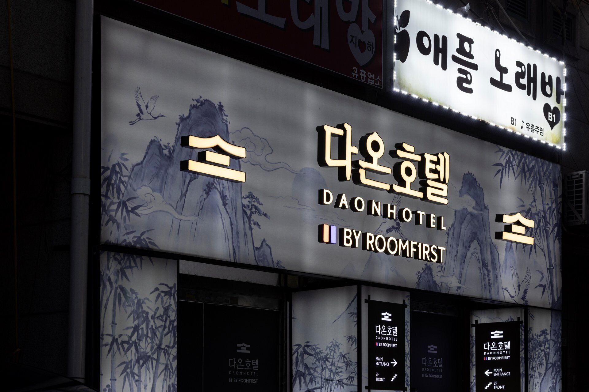 The exterior of Daon Hotel, featuring a traditional design with bamboo artwork and clear signage for the main entrance and front desk.