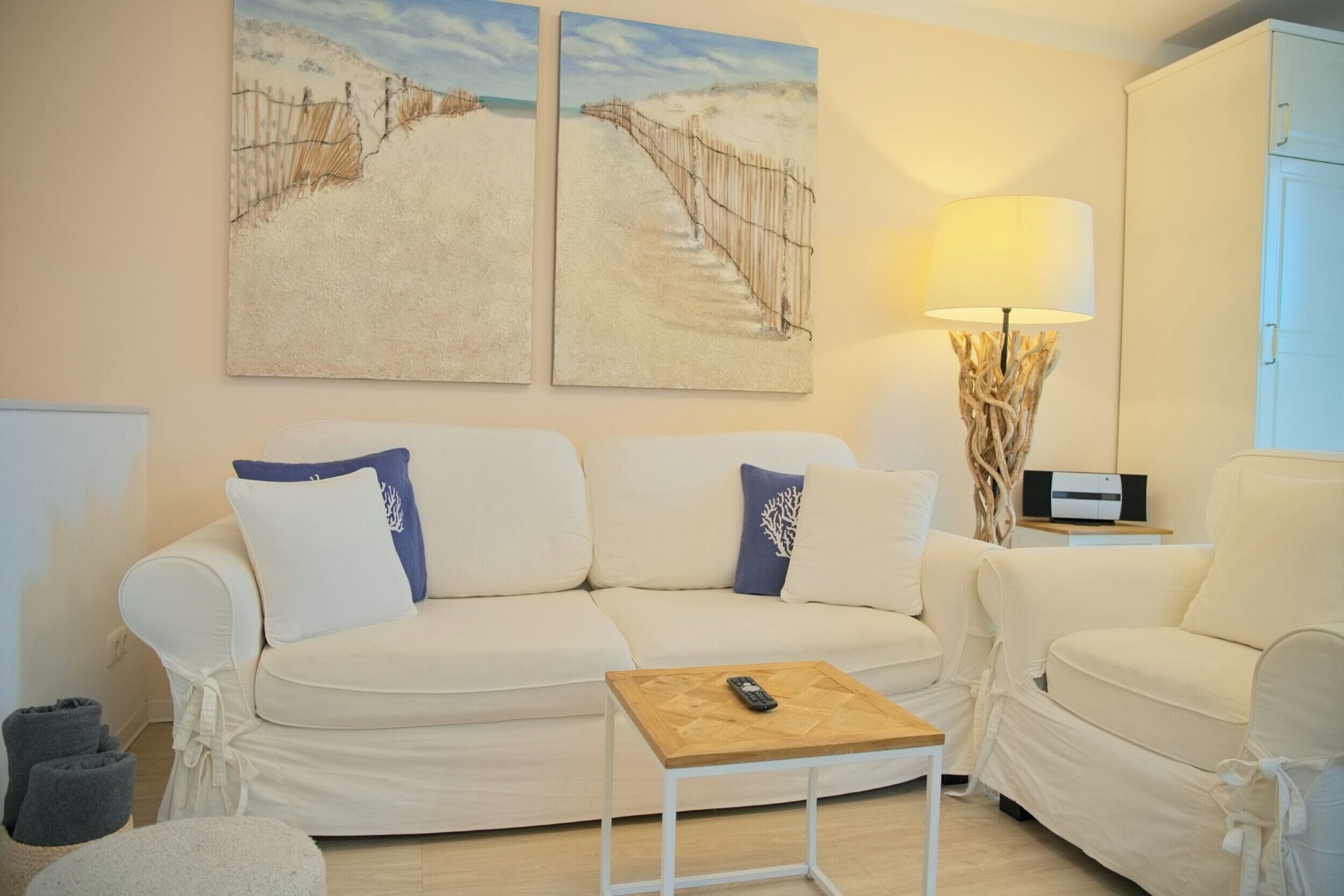 A living room with a beige sofa, a wooden coffee table, and a lamp.