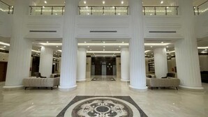 A spacious lobby with high ceilings, large columns, and a central ornate rug. - Manara Al Muna-2 (Makkah)