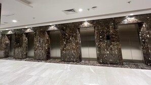 A modern elevator area with marble walls and a polished floor. - Manara Al Muna-2 (Makkah)
