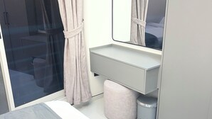 Et moderne badeværelse med glasbrusekabine, vaskebord med spejl og toilet.