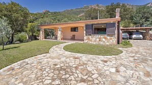 Un camino empedrado de piedra que conduce a una casa con fachada de piedra y un porche cubierto.