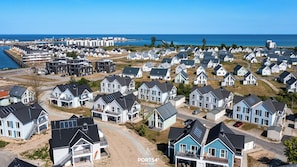 A coastal residential area with modern houses, a marina, and a view of the sea. - Rooftop Garden 6 - Sea View, Balcony, Private Parking Space, Fireplace, Sauna (Olpenitz)