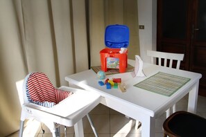 Ein weißer Tisch mit einer roten Plastik-Aufbewahrungsbox, einem Globus und bunten Bauklötzen.