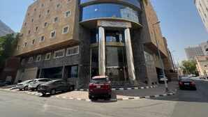 Ein Hotel mit modernem Design, das eine geschwungene Fassade und große Glasfenster aufweist.