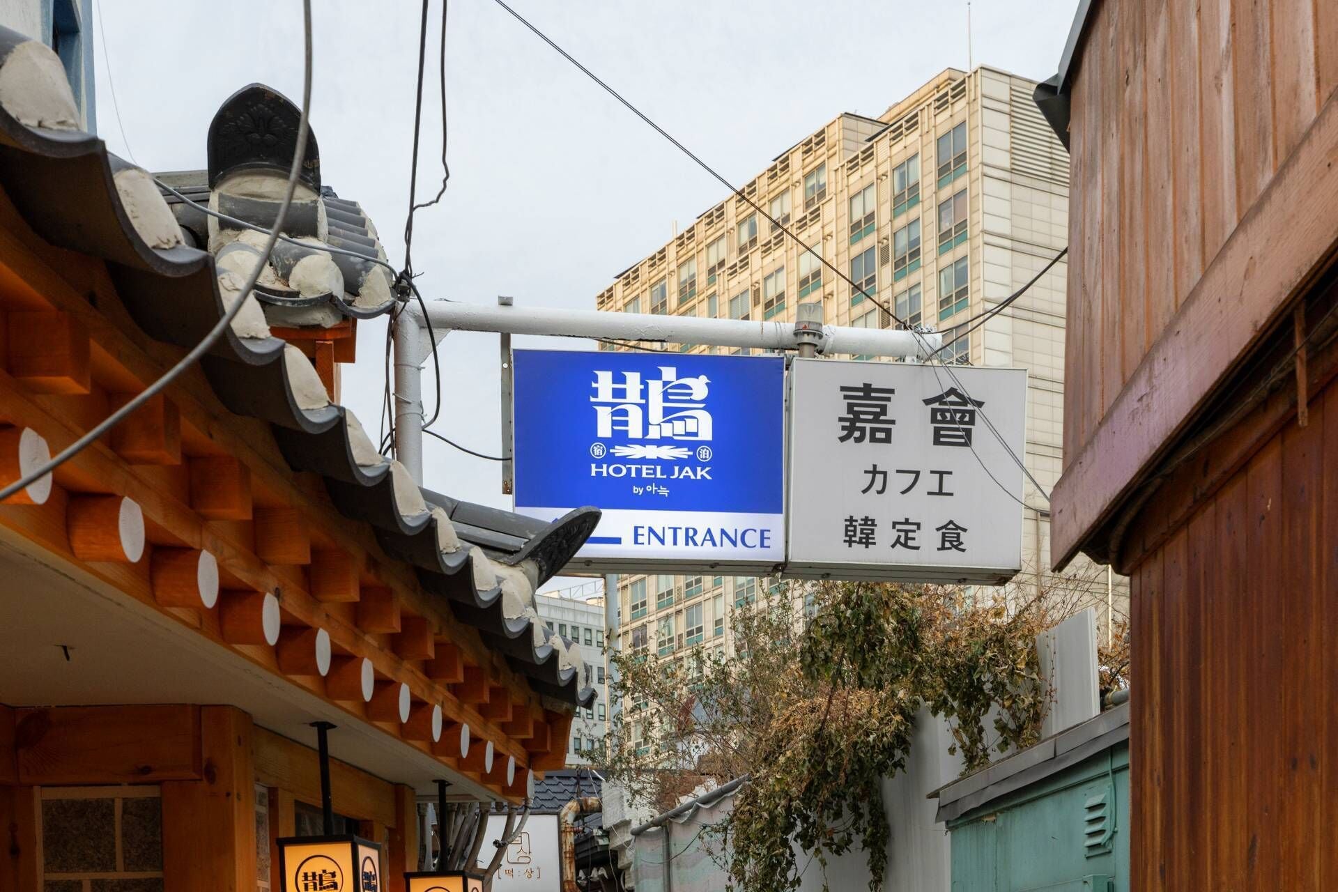 Un bâtiment traditionnel japonais, avec une enseigne indiquant « Hôtel Jak » et une autre indiquant un restaurant appelé « Kaito ».