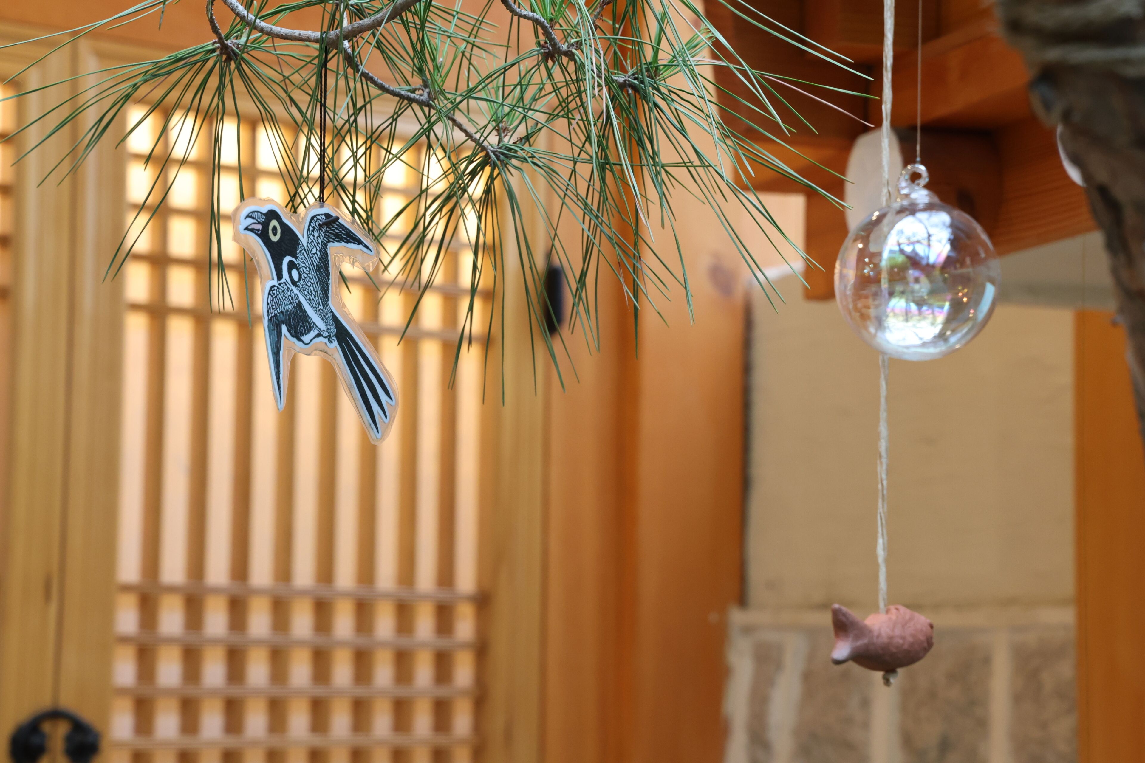 Ein vogelähnliches Ornament hängt an einem Zweig der Tanne.