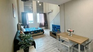 A compact room with a bed, a small table, a chair, a plant, and a window with curtains. - The CEO Suite7 by Homey Planet (Bayan Lepas)