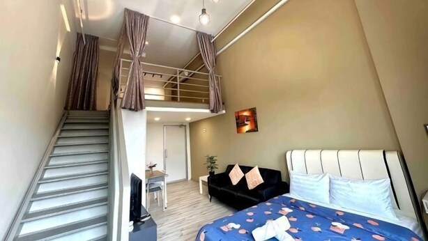 A bedroom with a bed, a desk, a chair, a staircase, and a balcony. - The CEO Suite7 by Homey Planet (Bayan Lepas)