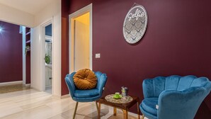 Un salon moderne avec deux fauteuils bleus, une petite table en bois et un élément décoratif mural.