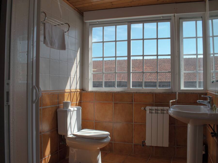 Un baño con inodoro, lavamanos y ventana.