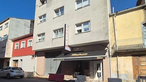 Een gebouw met een bord voor 'Hostal Galicia' en een 'Mahou' winkel.