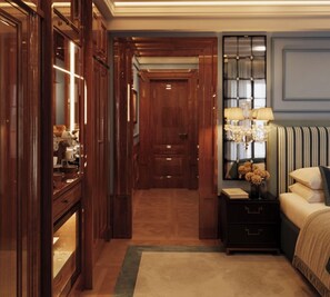 A hotel room with a wooden wardrobe, a nightstand with a lamp, a bed with a striped headboard, and a mirror with a decorative frame. - Locanda Cipriani Torcello (Venice)