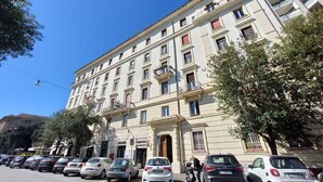 Un edificio de varios pisos con un estilo arquitectónico clásico, que presenta balcones y ventanas amplias.