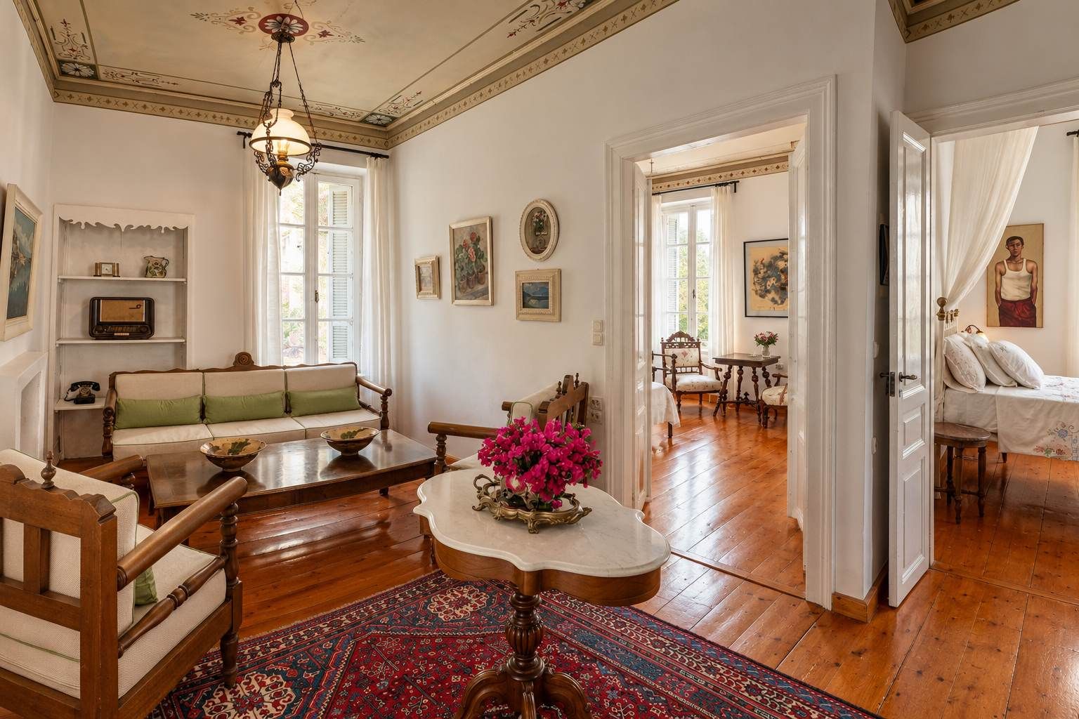A spacious living room with a wooden floor, a sofa, a coffee table, and a dining area with a table and chairs.