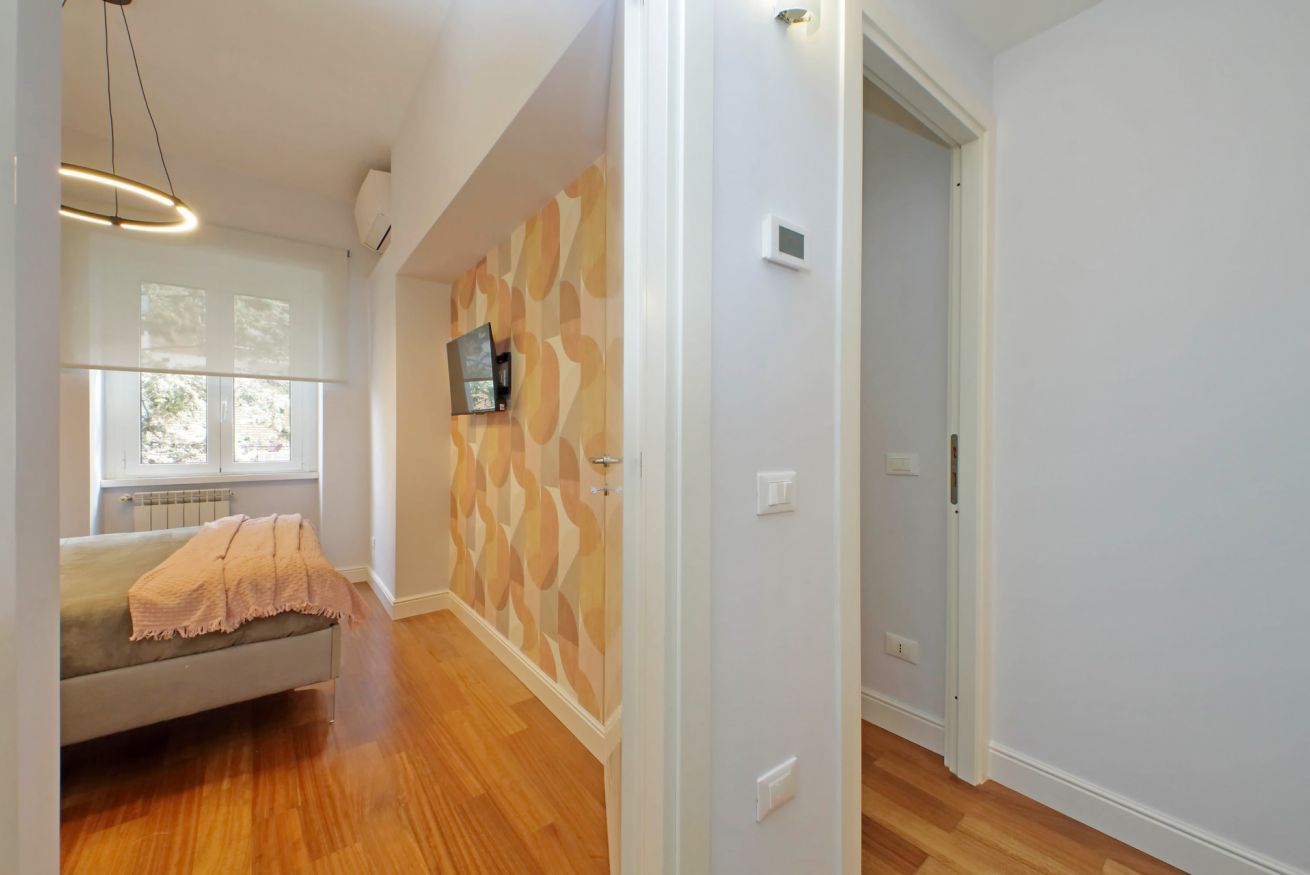 A modern room with a sofa, a patterned wall, and a wooden floor.