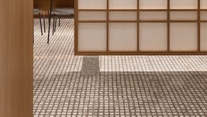 Een modern interieur met een houten scheiding, betegelde vloer en een keuken met aanrecht en stoelen.