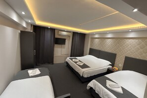 A hotel room with two beds, a flat-screen TV, and a minibar. - Grand Sezgin Hotel (Istanbul)