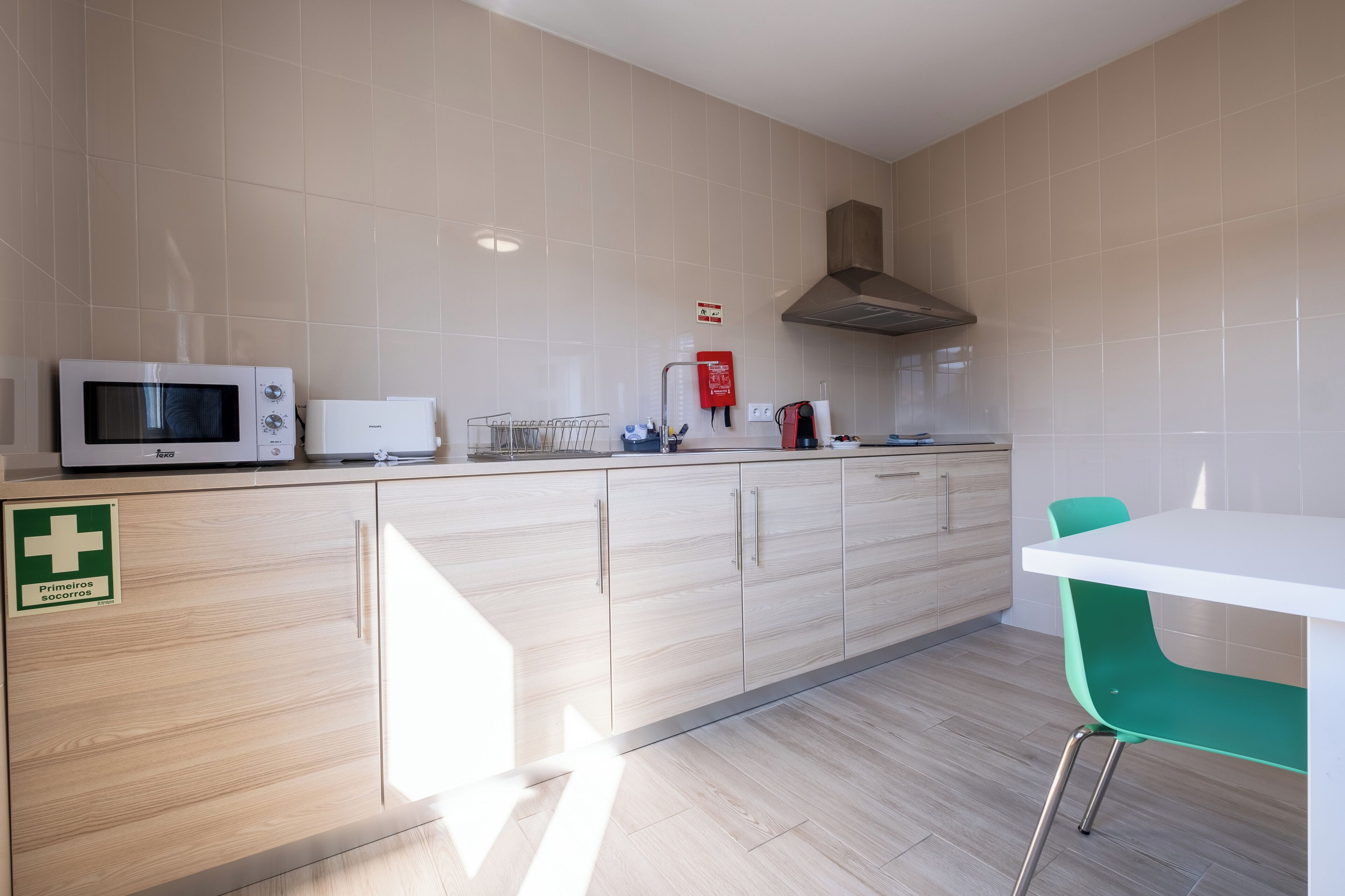 Una cocina moderna con microondas, cafetera y extintor.