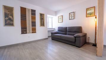 Deluxe-huoneisto, 1 keskisuuri parisänky ja vuodesohva, patio, näköala pihalle | Oleskelualue