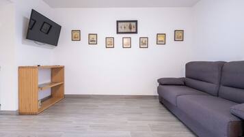 Deluxe appartement, 1 queensize bed met slaapbank, patio, uitzicht op binnenplaats | Woonruimte