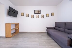 Deluxe appartement, 1 queensize bed met slaapbank, patio, uitzicht op binnenplaats | Woonruimte