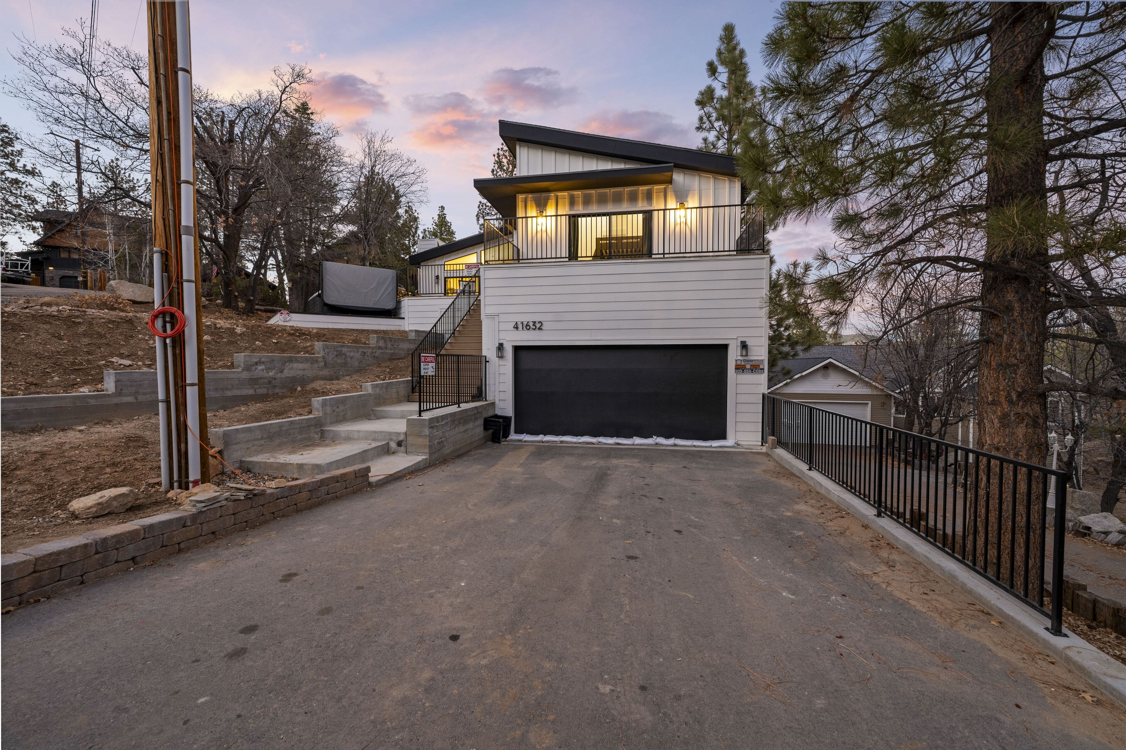 A modern two-story house with a garage, a staircase leading to the upper level, and a driveway.