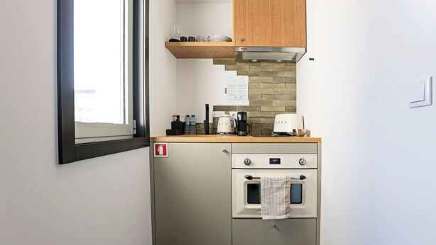 A compact kitchenette with a built-in oven, a coffee maker, and a small countertop. - Regras Apartments & Garden A14 by Benefit Collection (Porto)