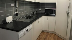 Una cocina compacta equipada con lavavajillas, microondas y refrigerador.